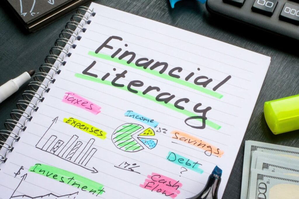 notebook with financial literacy written across it along with other finance graphs and terms