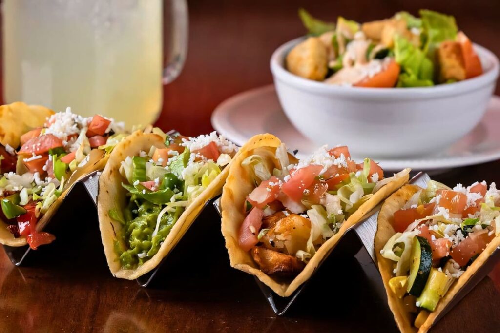 Assorted taco combos with a mug of margarita