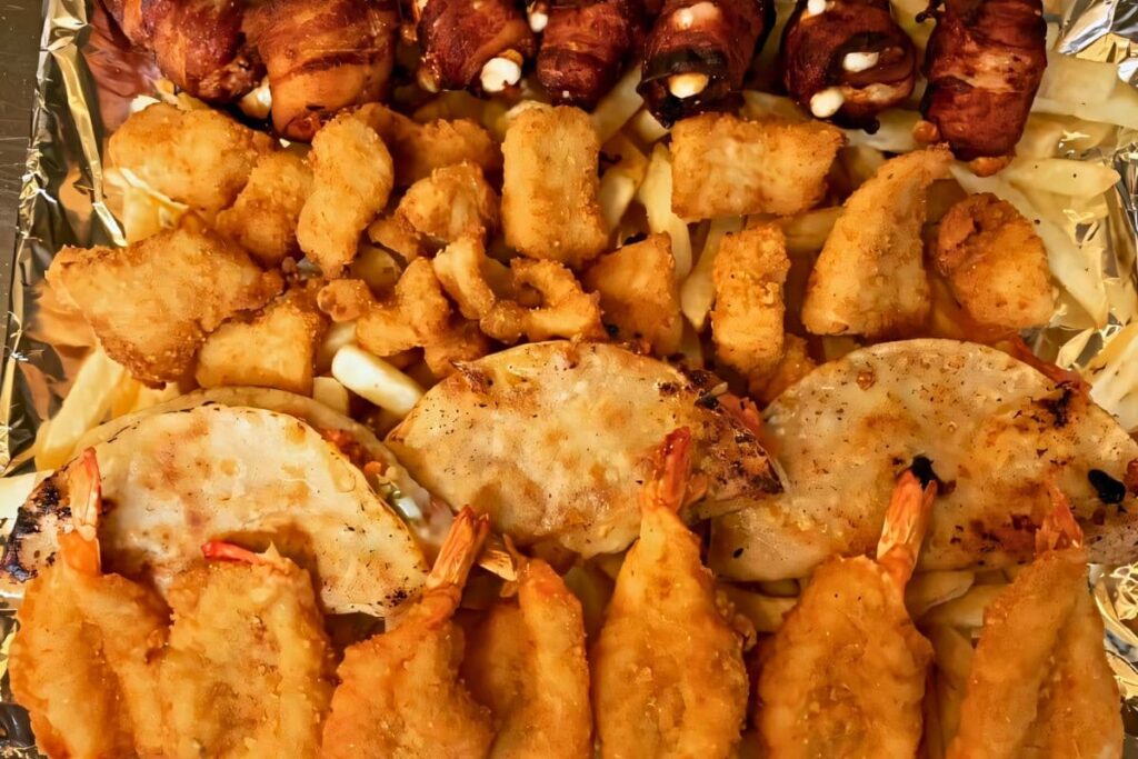 Seafood sampler featuring butterfly shrimp, calamari, and more