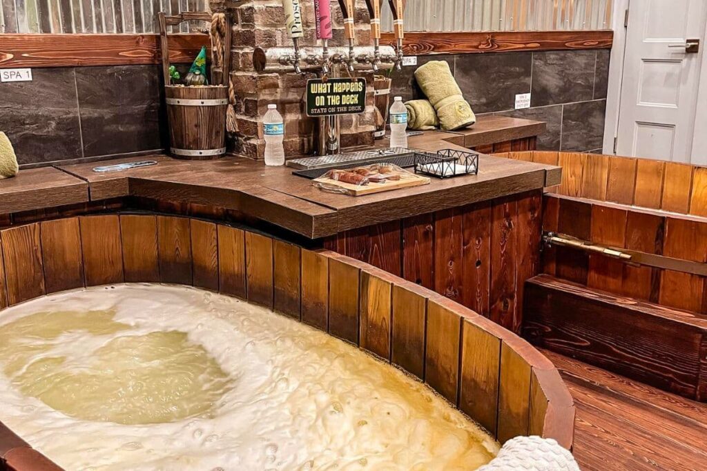 Wooden spa tub filled with beer and beer tap
