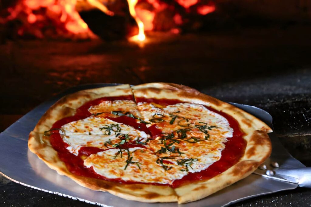 Margherita Pizza coming out of a wood fire oven