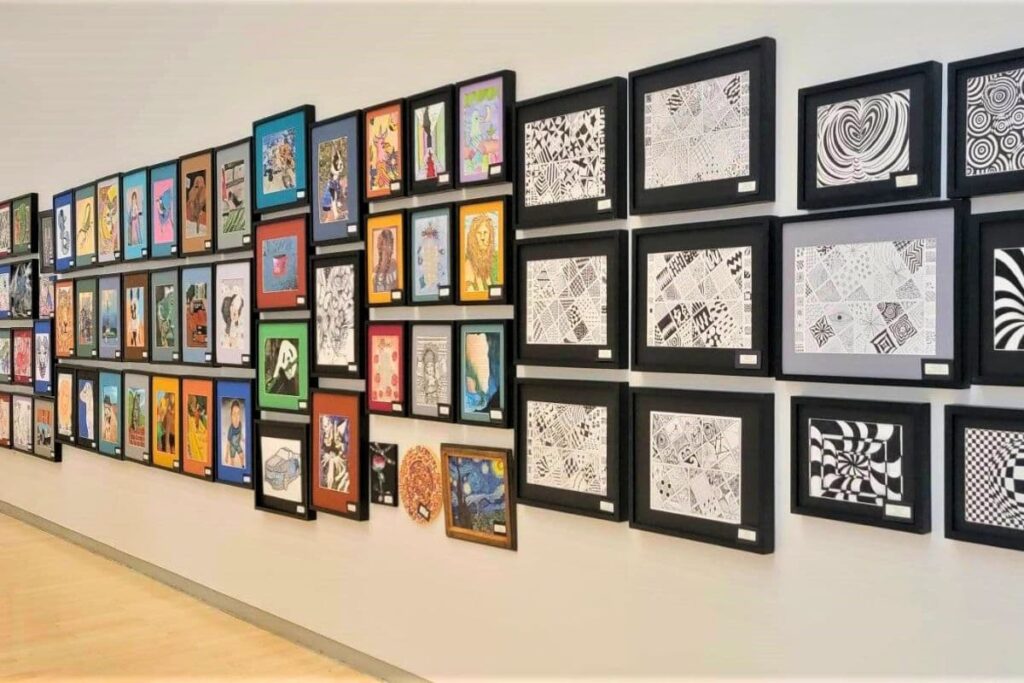 Yuma Art Center wall displaying wide variety of paintings and drawings in various styles and themes